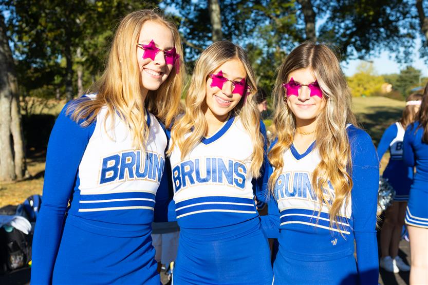 Three cheerleaders smile